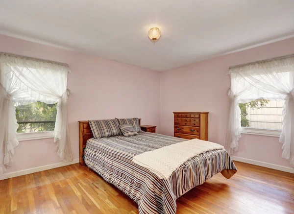 Interior del dormitorio con suelo de madera y suaves paredes de color rosa —  Fotos de Stock