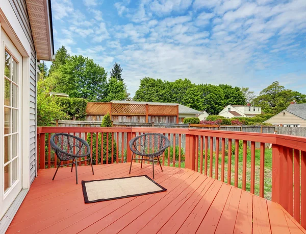 Backyard of craftsman home with red deck