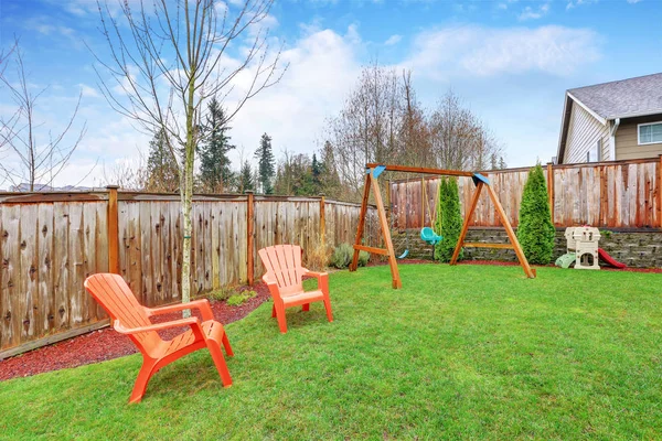 Playground area in the house backyard with swings — Stock Photo, Image