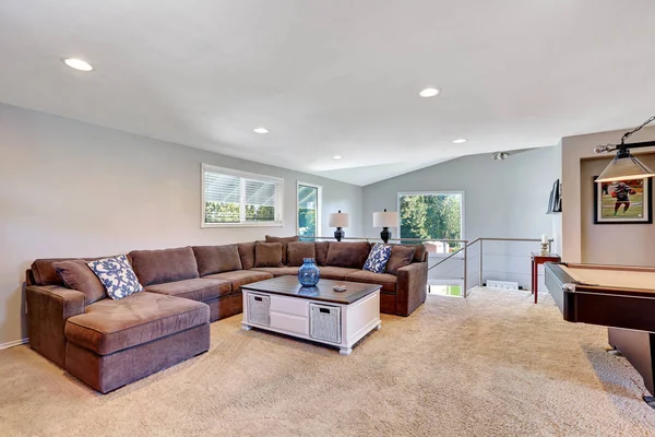 Cozy game room with brown sectional sofa — Stock Photo, Image