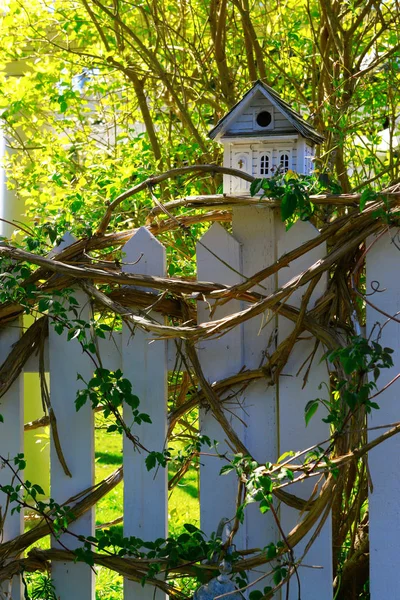 White wooden bird house on a picket fence post — Stock Photo, Image