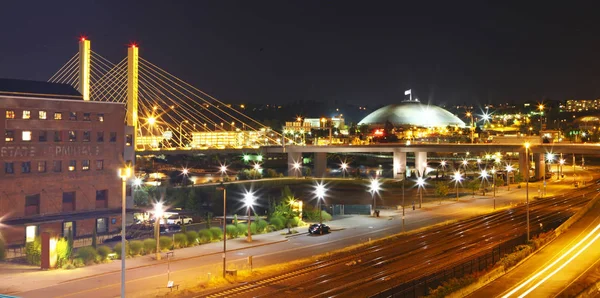 Tacoma centrum 's nachts met koepel en brug en snelweg. — Stockfoto