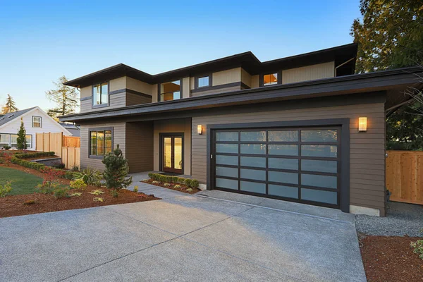 New construction home with low slope roof and brown siding. — Stock Photo, Image