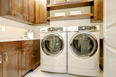White and brown laundry room with modern appliances  clipart