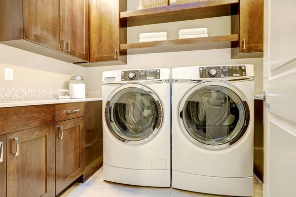 Bílé a hnědé prádelna s moderními spotřebiči — Stock fotografie
