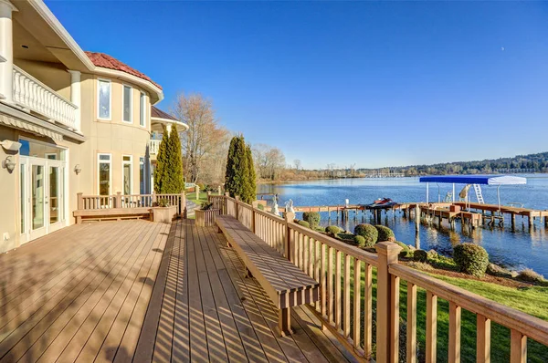 Sunny spacious walkout deck of luxurious waterfront home — Stock Photo, Image