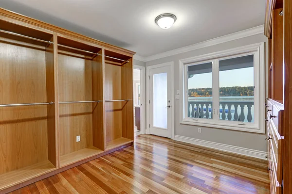 Empty walk in closet with hardwood floor and door to balcony — Stock Photo, Image