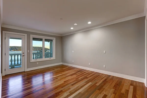 Pusty pokój z drewnianą podłogą i drzwi na balkon. — Zdjęcie stockowe