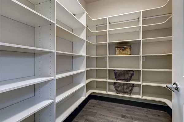 Open deur naar lege voorraadkast kamer met witte planken — Stockfoto