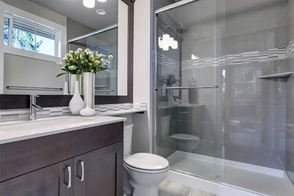 Bright new bathroom interior with glass walk in shower — Stockfoto