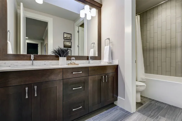 Vita och bruna badrum ståtar med en vrå fylld med dubbel fåfänga — Stockfoto