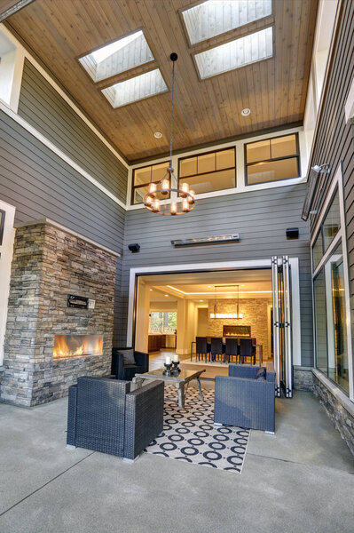 Gorgeous covered patio boasts high ceiling with skylights