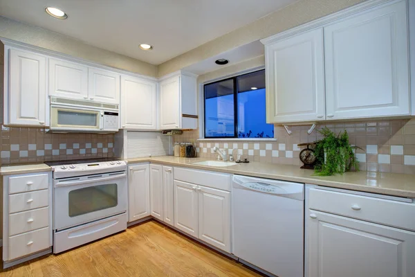 Projeto de cozinha branca com piso de madeira e aparelhos brancos — Fotografia de Stock
