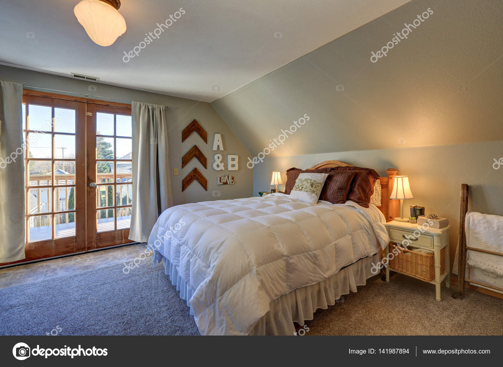 Tranquil Bedroom With Sloped Ceiling And Doors To Nice Deck