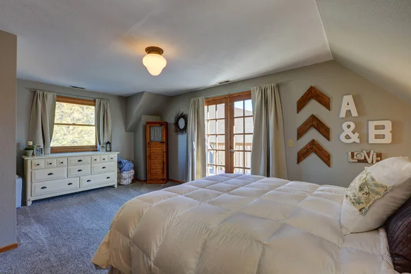 Dormitorio tranquilo con techo inclinado y puertas a la cubierta agradable . —  Fotos de Stock