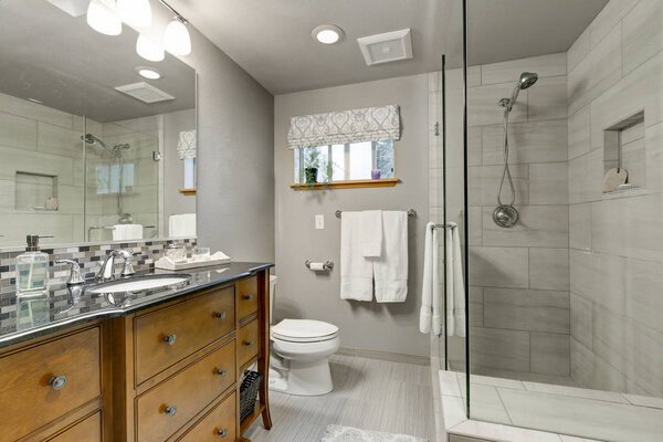 Grey bathroom interior with glass walk in shower
