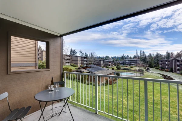 Blick vom Balkon der Wohnung auf grasbewachsenen Hügel und Pool — Stockfoto