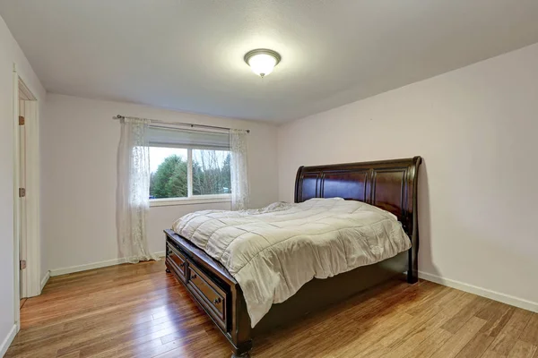 Chambre blanche avec lit en bois teinté foncé avec tiroirs inférieurs — Photo