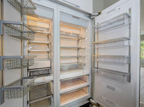 Huge modern refrigerator with empty shelves in a kitchen.