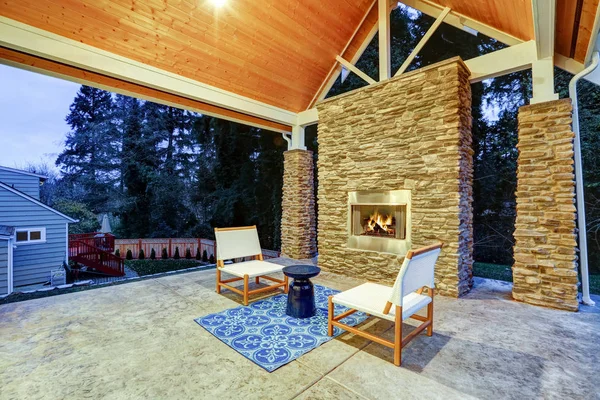 Elegante patio trasero cubierto con chimenea de gas construida — Foto de Stock