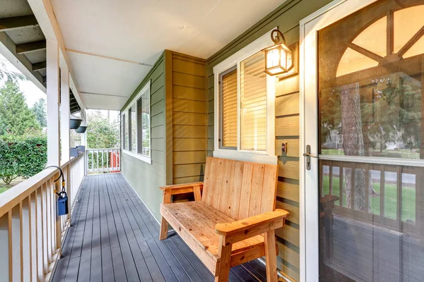 Überdachte Veranda mit Holzbank neben der Eingangstür — Stockfoto