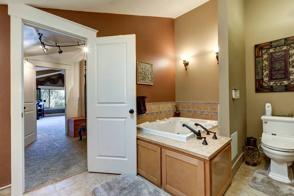 棕色的浴室内展示了角黑色大理石的浴缸 — 图库照片