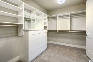 White walk-in closet with shelves, drawers and clothes rails clipart