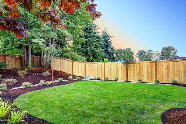 Nice fenced backyard with new planting beds — Stock Photo, Image