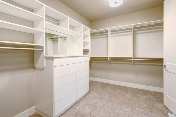 Walk-in closet blanco con estantes, cajones y rieles de ropa — Foto de Stock