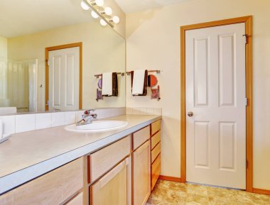 Sıcak bej banyo ile ışık ahşap dolaplar.