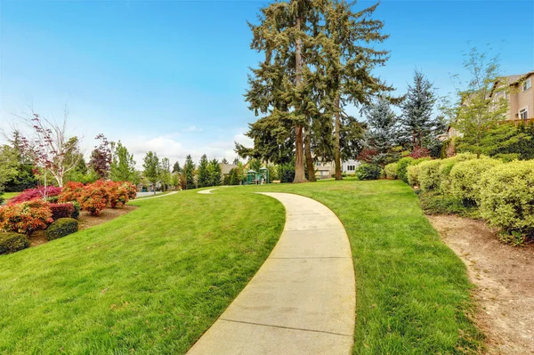 Concrete walkway leading to a park. — Stock Photo, Image