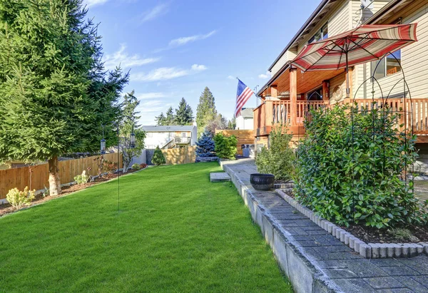 Zonnig terras met uitzicht op gemanicuurde achtertuin. — Stockfoto