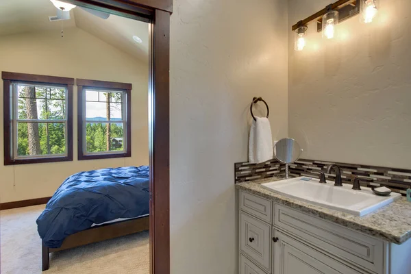 豊かな色の木製のドア 自然なベージュのカウンタートップ 白いキャビネットとシンクを備えた新しい豪華なバスルーム 明るい灰色の壁と床 — ストック写真