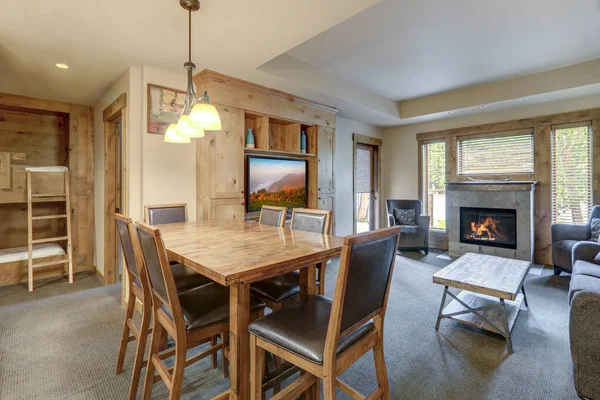 用灰色瓷砖 双层床和天然木料装饰的壁炉和漂亮的木制餐桌开一间漂亮的公寓 — 图库照片