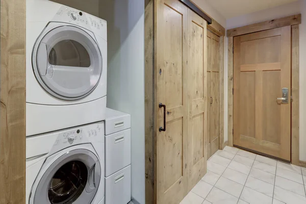 Nice laundry room white washer and dryer stack on each other in condo hallway.