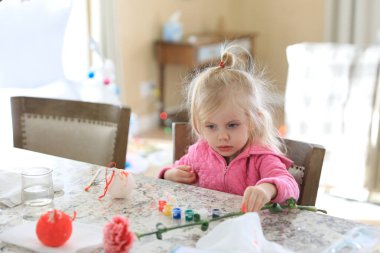 Küçük kız rahat evdeki mutfak tezgahında Noel balosunu resmediyor..