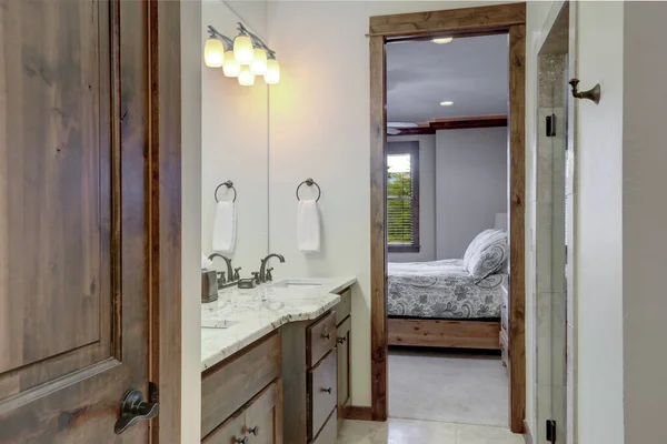 经典的简朴的小浴室内饰有浓郁的深色木柜门和敞开的卧室大门 — 图库照片