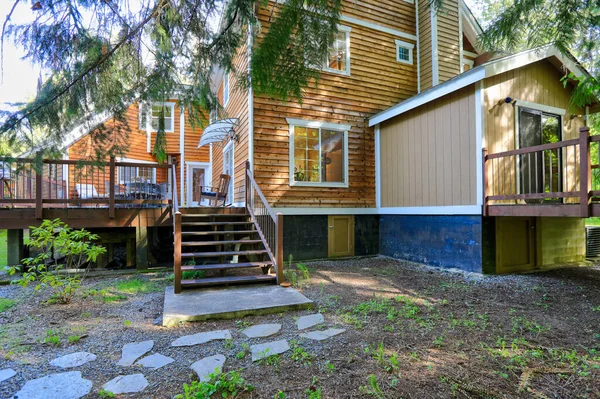 白いトリムとダブルガレージと緑の夏の自然と自然な茶色のトーンを持つ木製の大規模なアメリカの家 — ストック写真