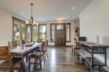 Uzun kırsal ahşap masa ve modern metal sehpa ile parlak bir oturma odası aç..