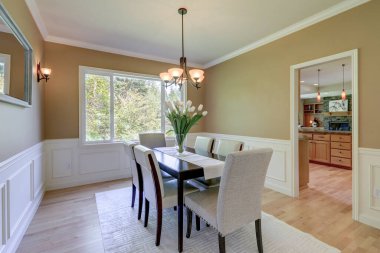 Klasik hardal rengi ve gri tonlu yemek odası. Büyük masa ve keten sandalyeler..