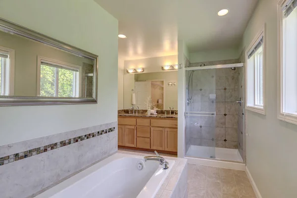 シャワー付きのウォーキン付きの大規模な古典的なマスターベッドルームバスルーム 2つのシンク付きの浴槽と木のキャビネットで焼く — ストック写真