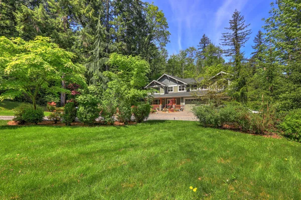 Schöne Lange Zweistöckige Northwest Home Exterior Graugrün Mit Frühling Landschaft Stockbild