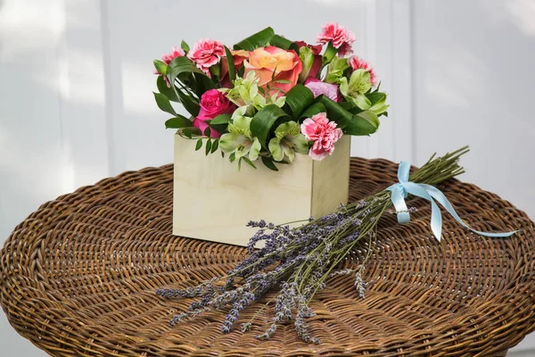 Bouquet in wooden box and a sprig of lavender.