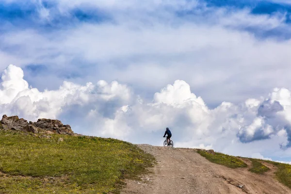 Rowerzysta na horyzoncie na tle chmur. — Zdjęcie stockowe