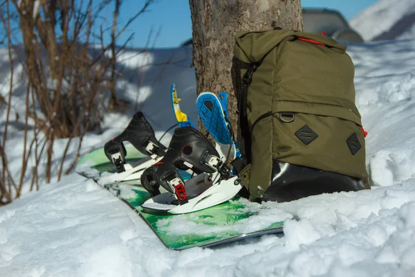 Un snowboard y una mochila en la nieve . —  Fotos de Stock