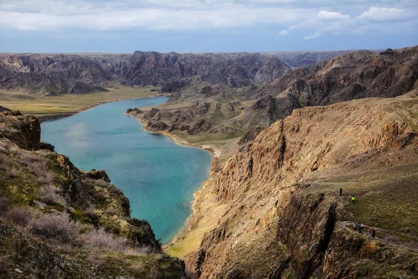 Een prachtige, turquoise rivier stroomt door een diepe kloof. Ili-rivier in het voorjaar. Kazachstan. — Stockfoto