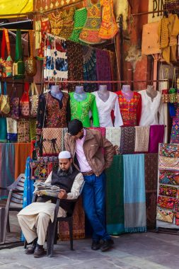 Jaipur, Hindistan - 10 Ocak 2018: Street giyim tüccarlar. Bir gazete okuyor