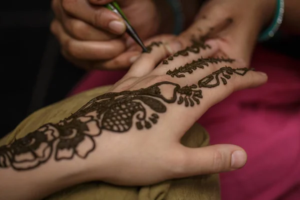 Het proces van het tekenen van een henna mehendi tekening op het meisje hand — Stockfoto