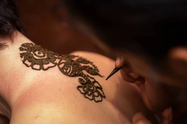 Proceso de dibujo del ornamento de henna mehendi en la espalda de la mujer — Foto de Stock