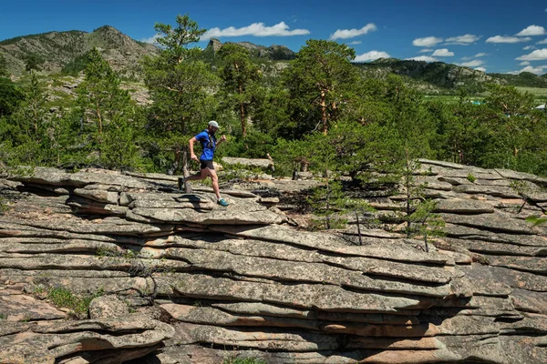 De atleet loopt op de rotsen in de bergen. Looppad buitenshuis — Stockfoto
